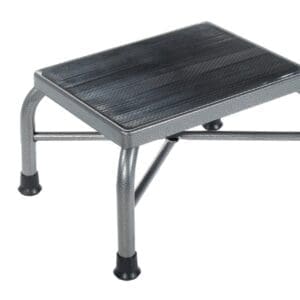 A small, metallic step stool with a black textured surface and four rubber-tipped legs. The stool has a simple, sturdy design and cross-support bars for stability.