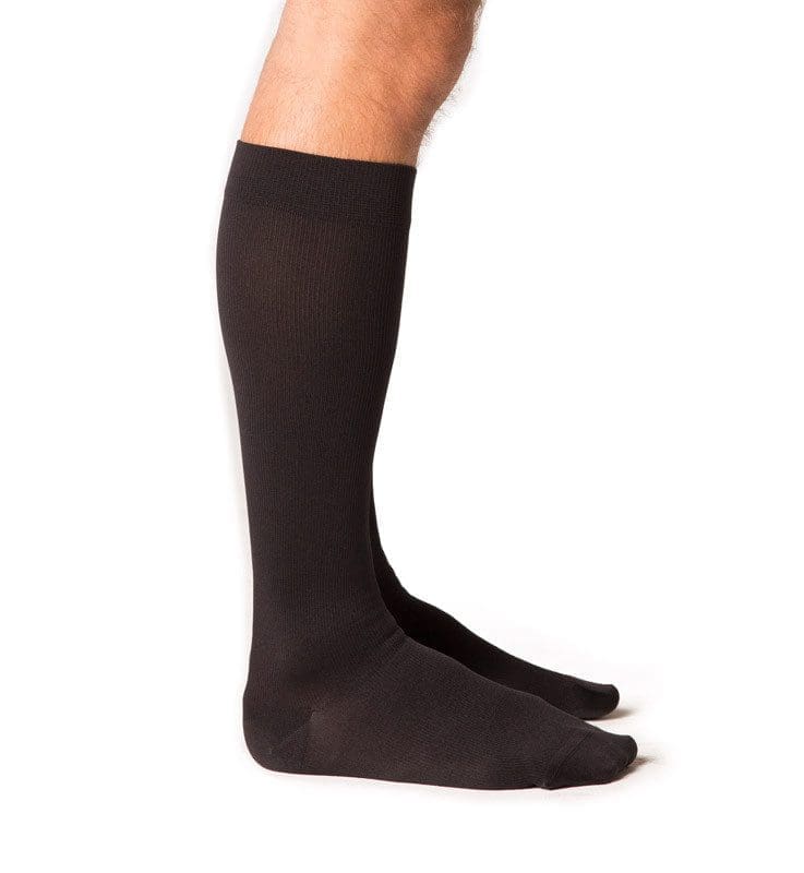 Side view of two legs wearing long, black socks that reach just below the knee. Set against a white background.