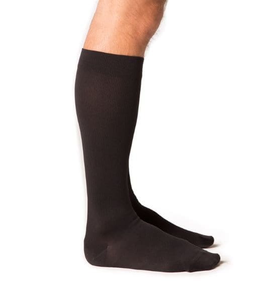 Side view of a person wearing knee-high black socks. The socks are plain and cover the calves, reaching just below the knees. The background is plain white, highlighting the socks.