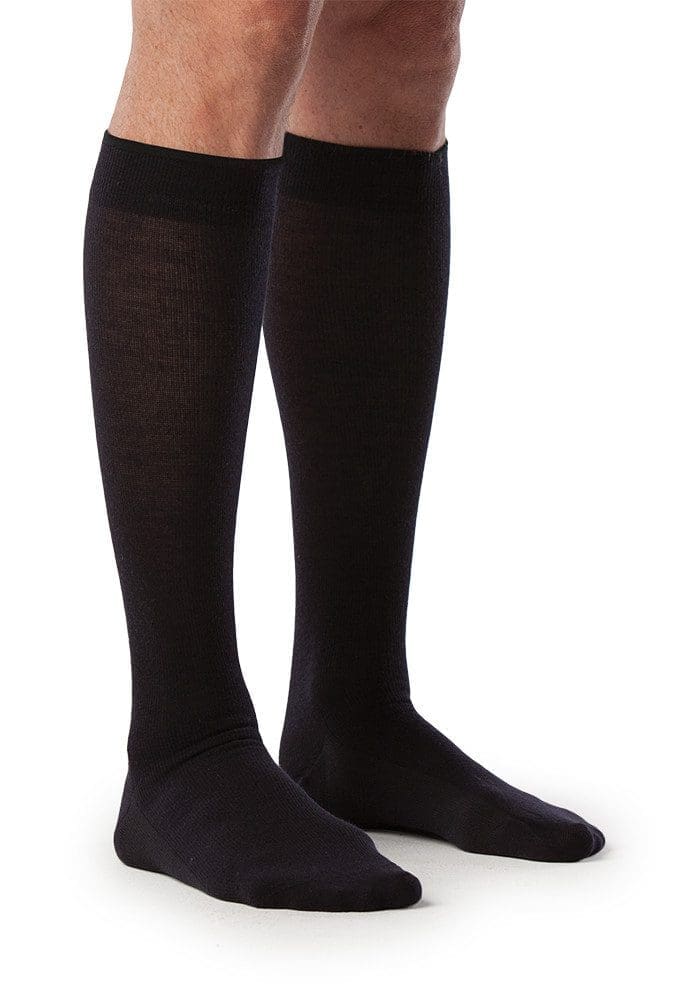 A pair of legs wearing knee-high black socks stands on a white background.