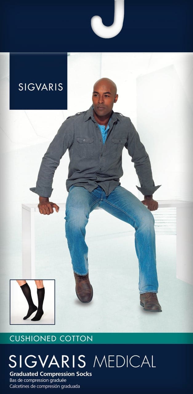 A man sits on a white surface, wearing a gray jacket and jeans. The background is light blue. An inset shows a pair of black graduated compression socks. The text reads SIGVARIS Medical Graduated Compression Socks.