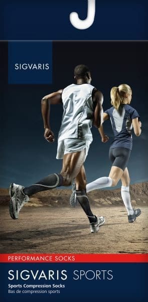 Two athletes running on a desert trail, wearing Sigvaris Sports compression socks. The man is in a white outfit, and the woman is in a blue top and black shorts. The background features a rocky landscape under a clear sky.
