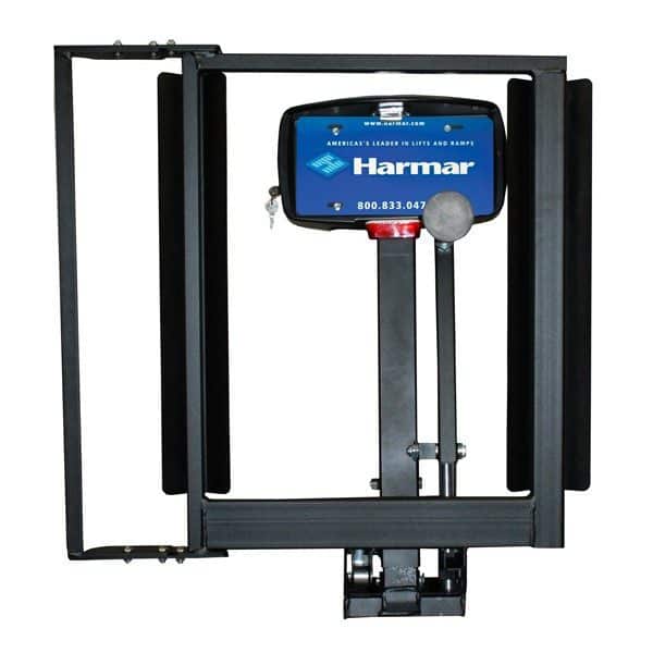 A Harmar vehicle lift platform with a blue control box and black metal frame, featuring the companys contact number. The lift is designed for mobility aids like wheelchairs and scooters.