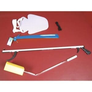 An assortment of adaptive tools on a red surface, including a blue long shoehorn, a white sock aid, a yellow sponge on a long handle, a black reacher, and a bundle of black elastic shoelaces.