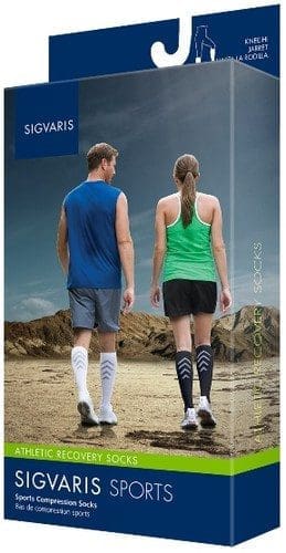 Packaging for Sigvaris Sports Compression Socks featuring two people walking on a rocky landscape, one wearing a blue top and white socks, the other a green top and black socks. The box highlights Athletic Recovery Socks on the front.