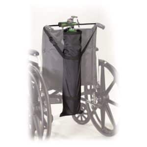 A wheelchair with a black carry pouch attached to the backrest, holding an oxygen tank. The wheels are large and the wheelchair is positioned against a light background.