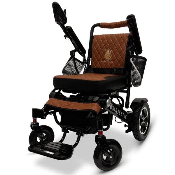 The MAJESTIC IQ-7000 features a brown quilted seat, armrests, and backrest elegantly embroidered with Majestic. It includes large rear wheels, smaller front wheels, and side storage pouches for your convenience.