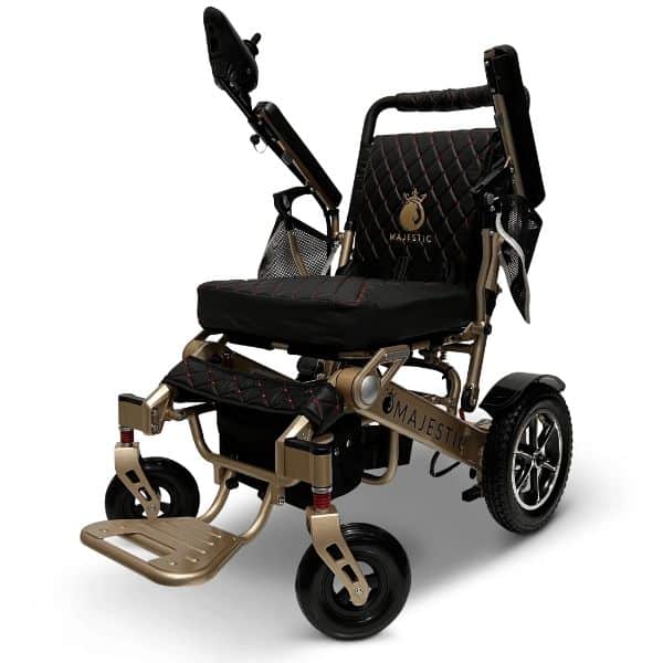 Meet the MAJESTIC IQ-7000, an auto-folding, remote-controlled electric wheelchair with a sleek black and gold design. It features quilted padding, joystick control, rear wheels for stability, and Majestic elegantly embroidered on the seat back—ideal for those seeking style and convenience.