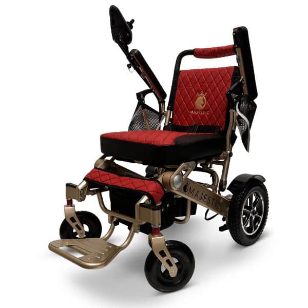 The MAJESTIC IQ-7000 Auto Folding Remote Controlled Electric Wheelchair features a red and black quilted design, sleek metallic frame, large rear wheels, armrests, footrests, a storage pouch, and an embroidered logo on the backrest for added style.
