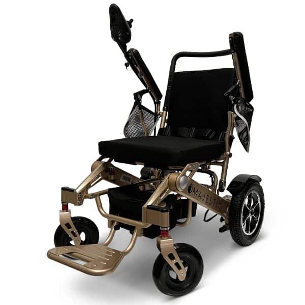 The MAJESTIC IQ-7000 Wheelchair is a compact, lightweight model with a black seat, gold frame, foldable armrests, a rear mesh storage pocket, and small front wheels paired with larger rear ones for easy mobility and transport.