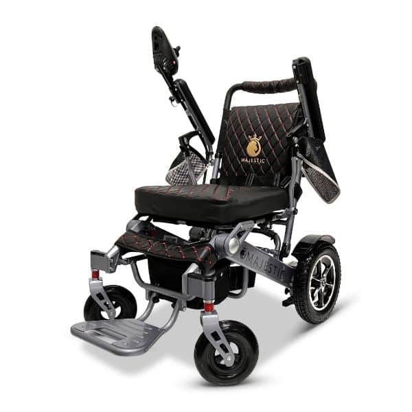 Meet the MAJESTIC IQ-7000 Auto Folding Electric Wheelchair: featuring a sleek black design accented with red stitching, armrests, a cushioned seat, and footrest. With large rear wheels and nimble front wheels, it ensures smooth mobility.