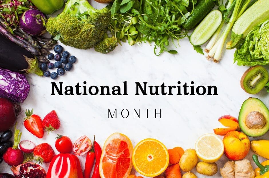 Colorful array of fruits and vegetables, including broccoli, blueberries, avocado, and citrus, surrounds the text National Nutrition Month on a marble background.