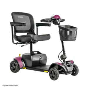 The GoGo Elite Traveller 2 by Pride is a compact mobility scooter with a padded seat, armrests, sturdy handlebar, front storage basket, and four wheels for stability. Its sleek design features black and purple accents, making it stylish and functional.