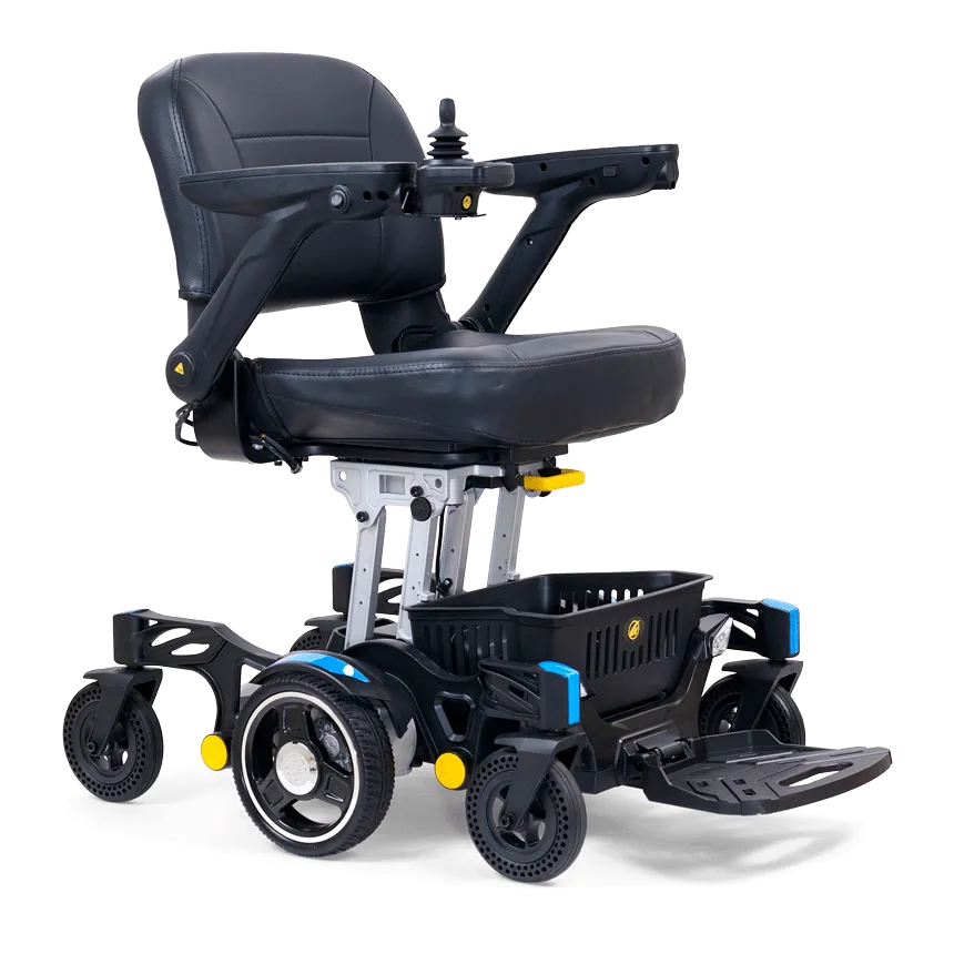 The Buzzaround Carry On Powerchair is a black electric wheelchair with a padded seat, armrests, joystick controls, and sturdy wheels. It features a small storage basket underneath and a foldable footrest for easy transport.